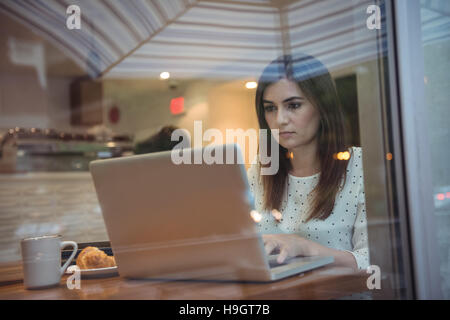 Imprenditrice utilizzando laptop in cafÃ© Foto Stock