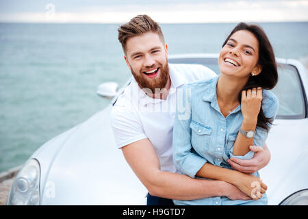 Sorridenti giovane su una data permanente auto vicino al mare Foto Stock