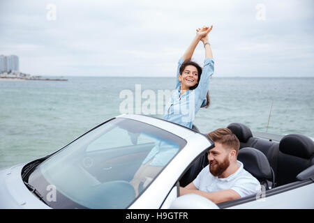 Coppia giovane in amore su strada Guida di Viaggio in autovettura convertibile Foto Stock