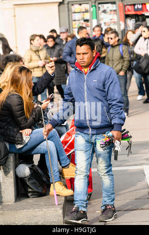 Uno dei molti venditori di strada comune nella maggior parte italiana città turistica, cercando di vendere selfie-stick e caricabatterie per telefono ai turisti. Foto Stock