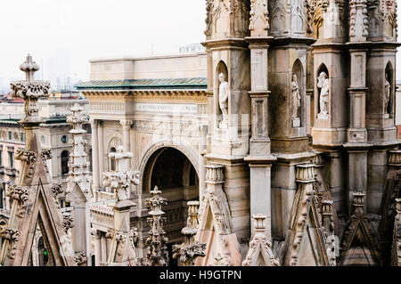 Riccamente intagliato muratura in pietra sul tetto del Duomo di Milano (Duomo di Milano), guardando sopra la Galleria Vittorio Emanuele II, Italia Foto Stock