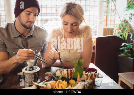 Giovane avente sushi Foto Stock