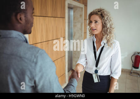 I dirigenti aziendali stringono le mani vicino a sollevare Foto Stock