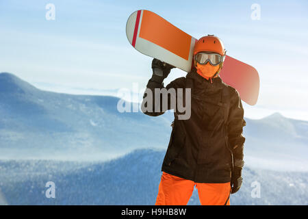 Snowboarder snowboard ritratto mountain top arancione Foto Stock
