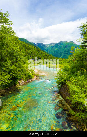 Le acque cristalline del Fiume di Azusa si snoda attraverso la foresta incontaminata con vista del paesaggio del monte Hotaka-Dake in Kamikochi Foto Stock