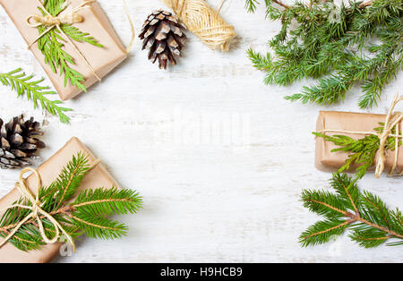 Decorazione di rami degli alberi, coni, doni su sfondo di legno Foto Stock