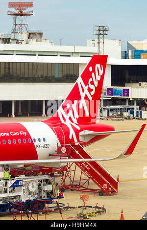 Scale auto parcheggiate presso la sezione di coda della Red Air Asia aereo nella parte anteriore della torre di controllo a Don Mueang airport. In verticale Foto Stock