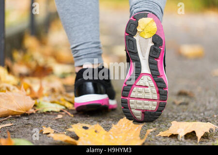 Close up di donna piedi indossando sneakers in autunno Foto Stock