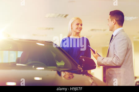 Donna felice con il rivenditore di auto in auto show o salon Foto Stock