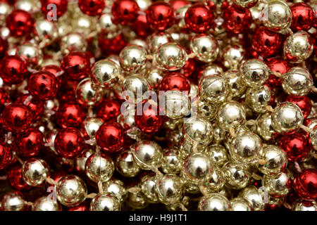 Pila di oro e cordone rosso Ghirlanda di Natale sfondo a tema. Foto Stock