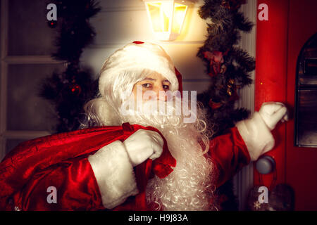 Il vero Babbo Natale. Santa bussa alla porta. La notte di Natale. Foto Stock