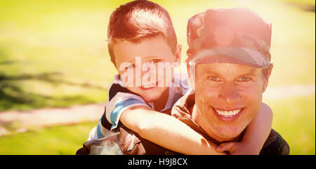 Felice soldato dando sovrapponibile al suo figlio Foto Stock