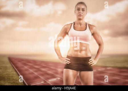 Immagine composita di atleta femminile in posa con le mani sul hip Foto Stock