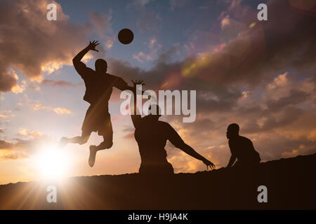 Immagine composita della vista posteriore di uno sportivo in posa mentre giocando a pallavolo Foto Stock