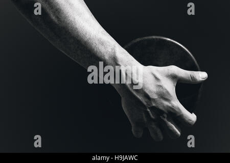Immagine composita della stretta di mano di uno sportivo è in possesso di un discus Foto Stock