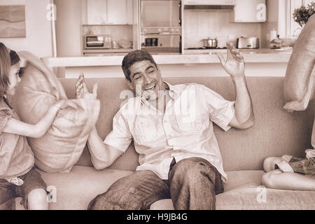 Famiglia avente pillow fight sul divano Foto Stock