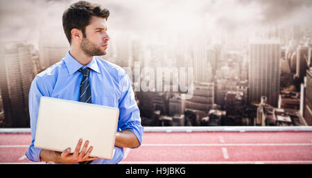 Immagine composita di imprenditore usando un computer portatile Foto Stock