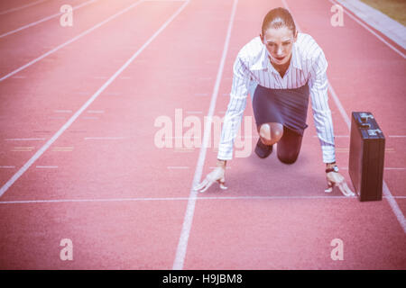 Immagine composita di concentrare la donna in blocchi di partenza Foto Stock