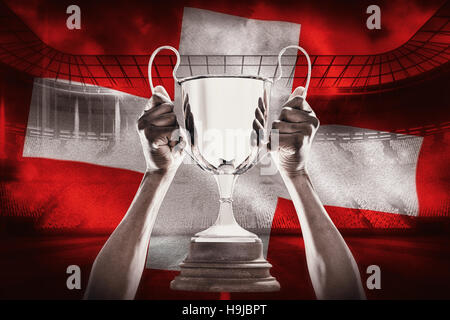 Immagine composita della mano ritagliata di atleta holding trophy Foto Stock