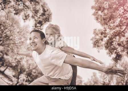 Padre figlia dando una piggy back in posizione di parcheggio Foto Stock