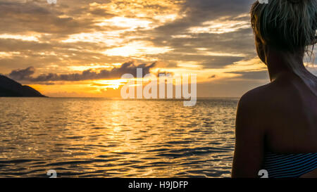 Silhouette di Jung Donne nella calda luce del tramonto, Kri Island. Raja Ampat, Indonesia, Papua Occidentale Foto Stock