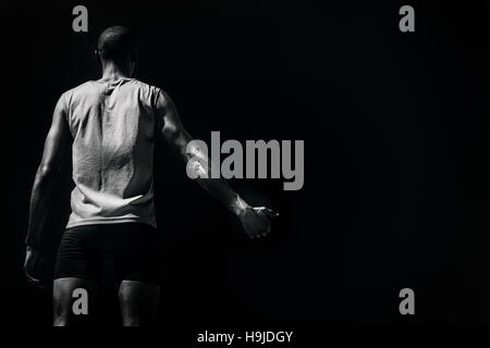 Immagine composita della vista posteriore di uno sportivo tenendo un discus su sfondo bianco Foto Stock