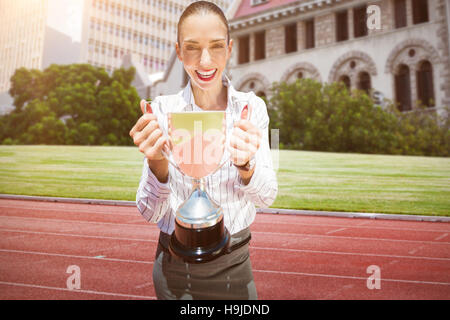 Immagine composita di Imprenditrice di successo tenendo un trofeo Foto Stock