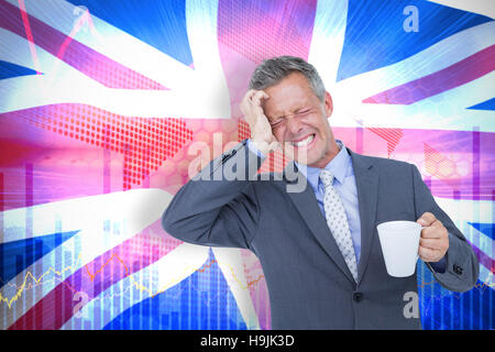 Immagine composita di imprenditore che soffrono di mal di testa tenendo tazza da caffè Foto Stock