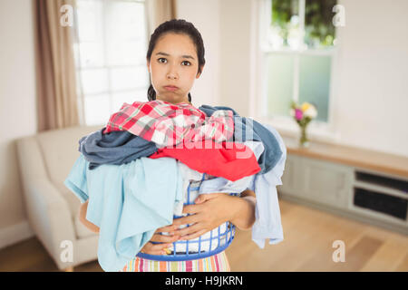 Immagine composita di stanchezza donna piena di contenimento un cesto della biancheria Foto Stock