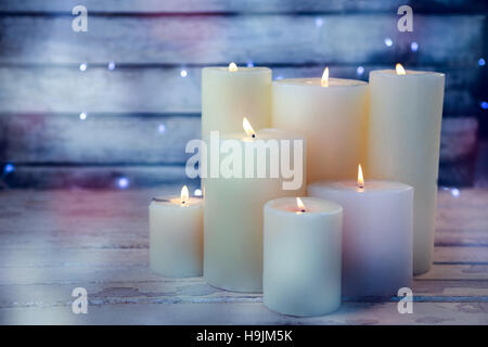 Candele accese sul tavolato in legno Foto Stock