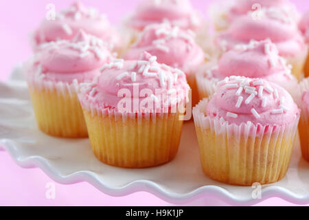 Delicato sapore dolce mini tortine di fragole sul piedistallo bianco cake stand su sfondo rosa in formato orizzontale. Profondità di campo. Foto Stock