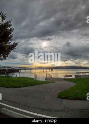 Nuvole scure nella parte anteriore del blocco di sole la sua luce al tramonto. Shot prese a Des Moines Marina nello Stato di Washington. Foto Stock