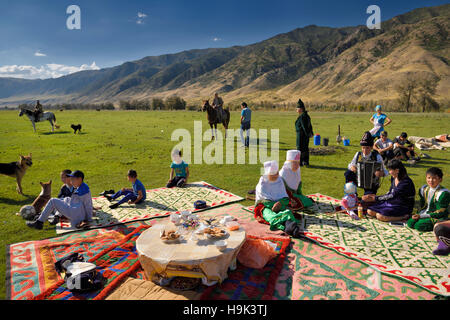 Soggiornare concittadini riuniti per un picnic in pascolo dal fiume Chilik e Kungey Alatau montagne Kazakistan Foto Stock