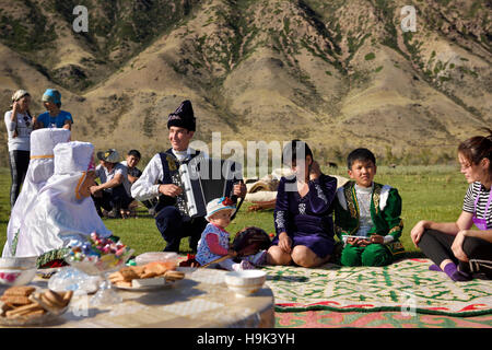 Soggiornare alcuni concittadini in abiti tradizionali a un picnic dal fiume Chilik Kungey Alatau montagne Kazakistan Foto Stock