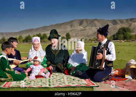 Tradizionale famiglia kazako cantare ad un picnic in pascolo di soggiornare Kazakistan Foto Stock