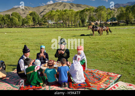 Tradizionale famiglia kazako dicendo grazia ad un picnic in Chilik river valley soggiornare Kazakistan Foto Stock