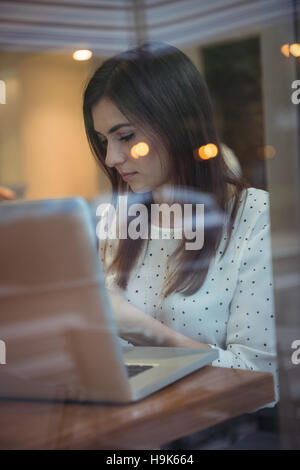Imprenditrice utilizzando laptop in cafÃ© Foto Stock