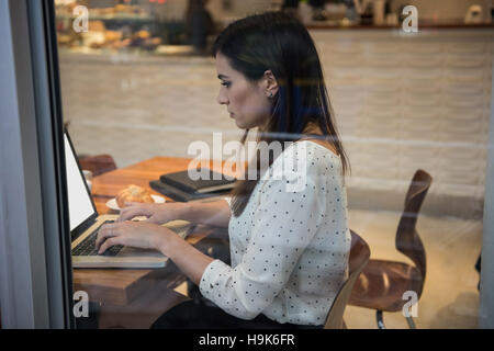 Imprenditrice utilizzando laptop in cafÃ© Foto Stock