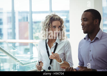 I dirigenti aziendali avente una discussione mentre si cammina nel corridoio Foto Stock