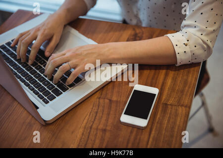 Imprenditrice utilizzando laptop in cafÃ© Foto Stock
