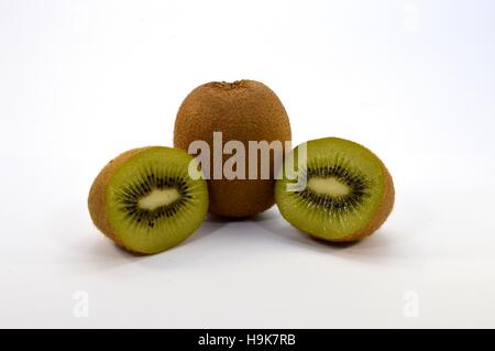 Kiwi interi e tagliati a metà su sfondo bianco Foto Stock