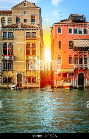 Gondole o barche sul canal grande nella bellissima città di Venezia con il tramonto del sole Foto Stock