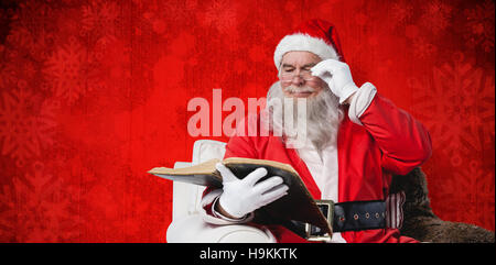 Immagine composita di santa claus leggendo la Bibbia su poltrona Foto Stock