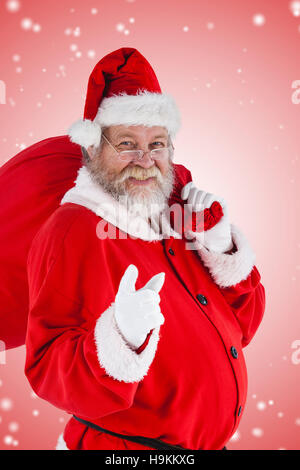 Immagine composita del ritratto di santa claus rivolta mentre porta sacco di natale Foto Stock