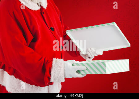 Immagine composita di santa claus apertura confezione regalo Foto Stock