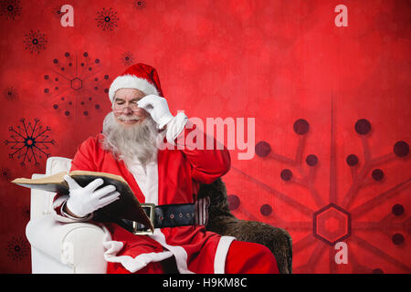 Immagine composita di santa claus leggendo la Bibbia su poltrona Foto Stock