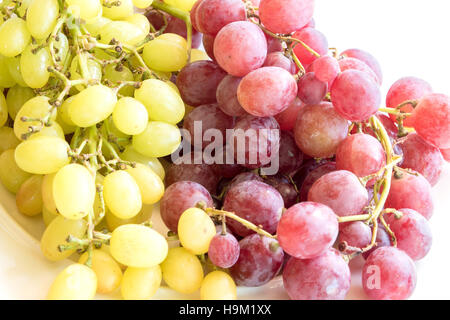 Il rosso e il verde uva su una piastra bianca, cibo closeup Foto Stock