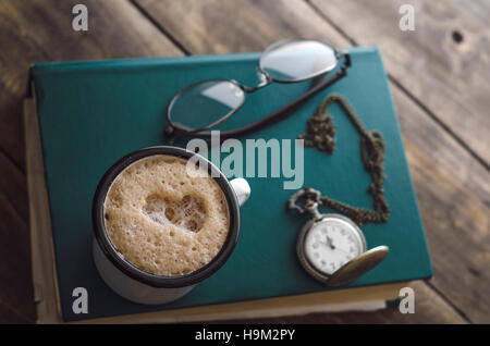 Vintage orologio da tasca con tazza di caffè sul vecchio libro, primo piano Foto Stock