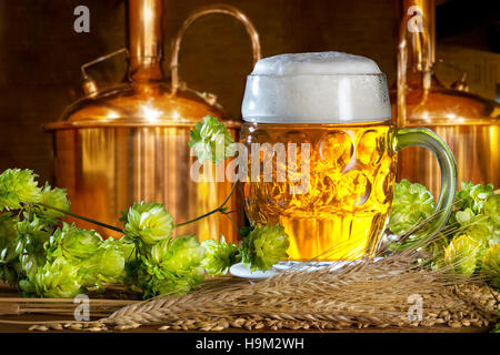 Bicchiere da birra con il luppolo e orzo in birreria Foto Stock