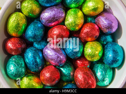 Foto di primo piano concettuale delle uova di pasqua al cioccolato avvolte in un foglio di alluminio colorato Foto Stock